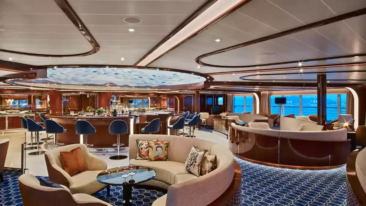 Salon panoramique du Seabourn Ovation, canapés arrondis et bar sur la mer