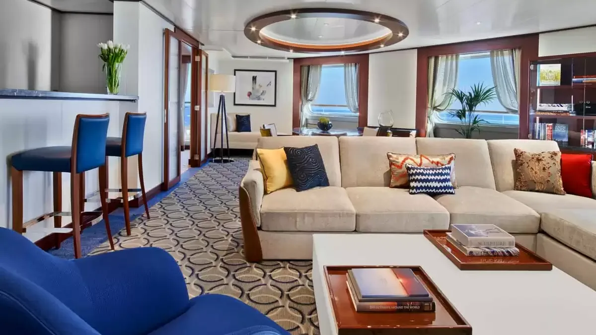 Grand salon d’une suite du Seabourn Ovation, canapé d’angle et coin bar