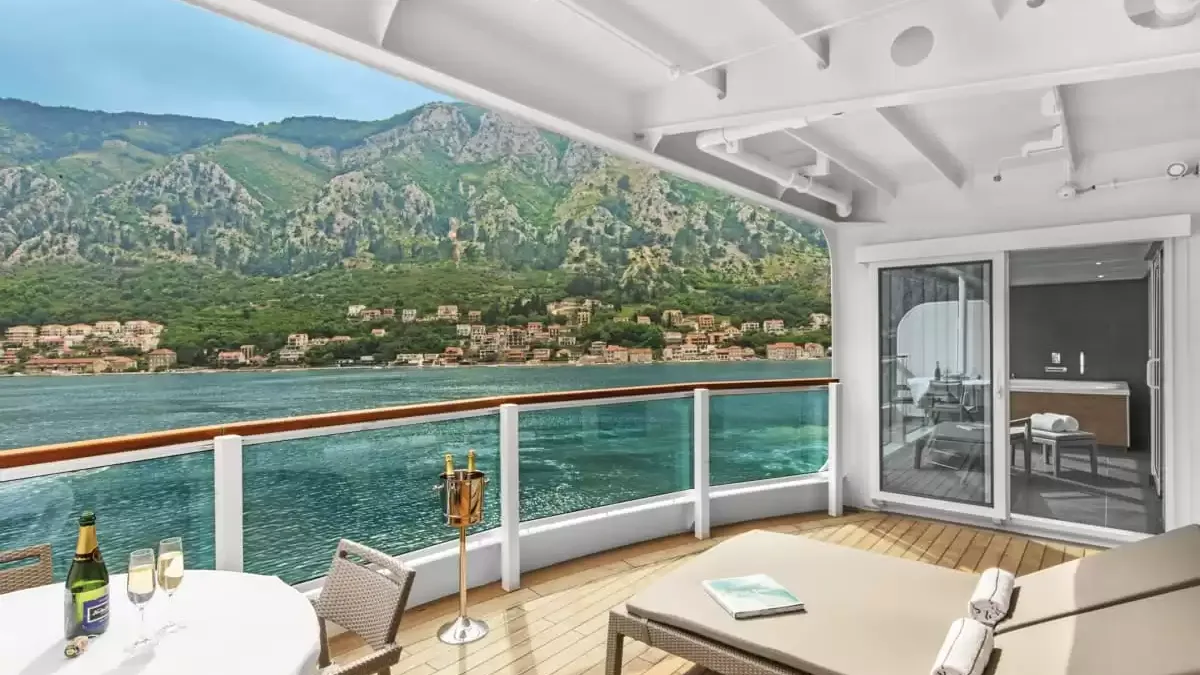 Balcon d’une suite du Seabourn Ovation, transats et table face à la côte