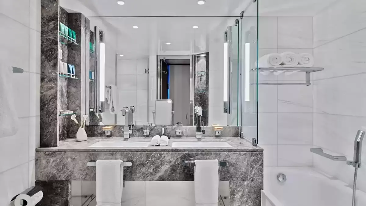 Salle de bains en marbre d’une suite du Seabourn Ovation, double vasque et baignoire